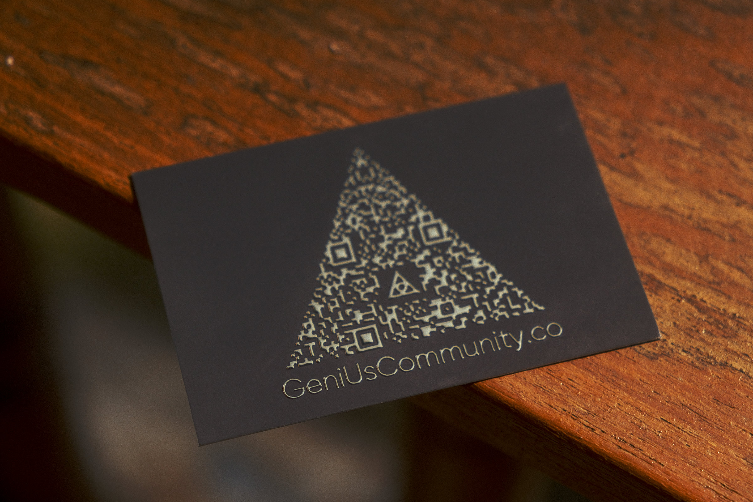 Back of the Genius Community business card, revealing the complex custom QR code.