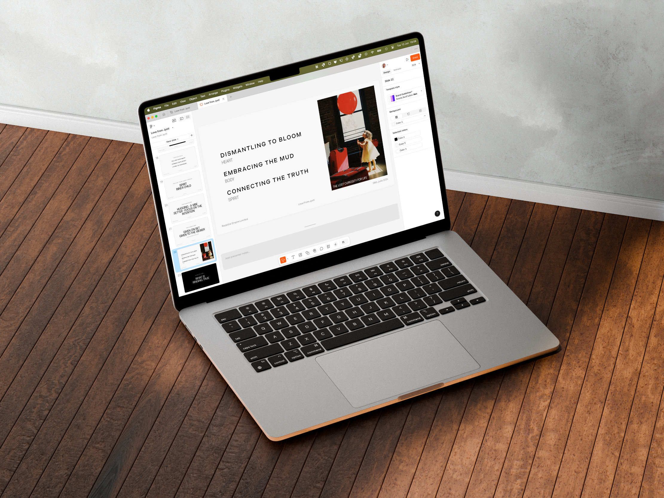 A laptop on a wooden floor displays a presentation slide with the titles Dismantling to Bloom, Embracing the Mud, and Connecting the Truth, alongside an abstract art image.